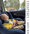 Smiling Baby in Car Seat with Yellow Sweater and Hat 136120321