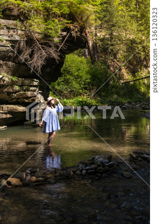 Woman Strolling by River in Forest 136120323