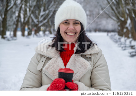 Woman Enjoying Hot Drink in Snowy Park Woman Enjoying Hot Drink in Snowy Park 136120351