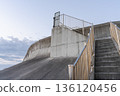 The calm curves of the seawall and stairs at Migita Beach in the morning glow 136120456