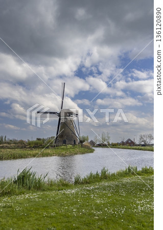 Traditional Dutch windmill standing by canal in Haastrecht 136120890
