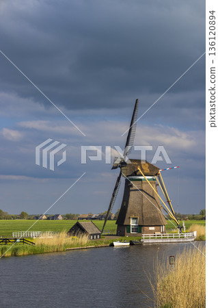 Traditional Dutch polder windmill standing beside canal in Groot Ammers Traditional Dutch polder windmill standing beside canal in Groot Ammers 136120894