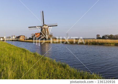 Traditional Dutch windmill De Lastdrager standing by canal Heerhugowaard Traditional Dutch windmill De Lastdrager standing by canal Heerhugowaard 136120916