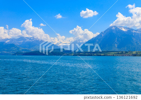 View of the Annecy lake surrounded by beautiful mountains in Annecy, France View of the Annecy lake surrounded by beautiful mountains in Annecy, France 136121692