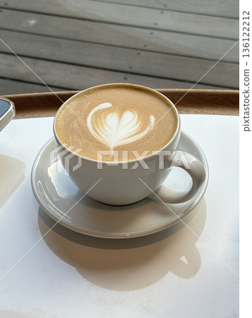 A beautifully crafted latte, featuring creamy foam art on top of rich espresso. Perfect for coffee-related projects, this image captures the warmth and inviting nature of a classic café experience. A beautifully crafted latte, featuring creamy foam art on top of rich espresso. Perfect for coffee-related projects, this image captures the warmth and inviting nature of a classic café experience. 136122212