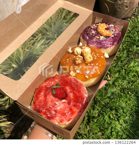 Delicious doughnuts with a golden, fluffy texture, topped with colorful glazes and sprinkles. Perfect for dessert or breakfast photography, showcasing the sweet indulgence of these classic treats. Delicious doughnuts with a golden, fluffy texture, topped with colorful glazes and sprinkles. Perfect for dessert or breakfast photography, showcasing the sweet indulgence of these classic treats. 136122264