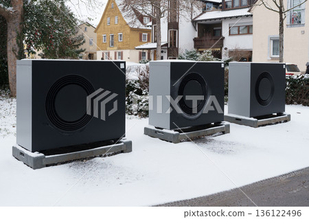 Row of modern heat pumps outside residential buildings in winter 136122496