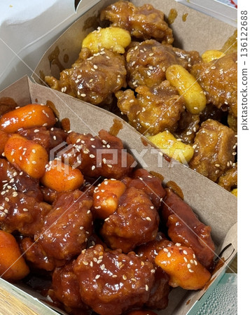 Crispy Korean fried chicken, perfectly glazed with a sweet and spicy sauce. Ideal for food photography and menus, showcasing the irresistible crunch and flavor of this beloved dish. 136122688