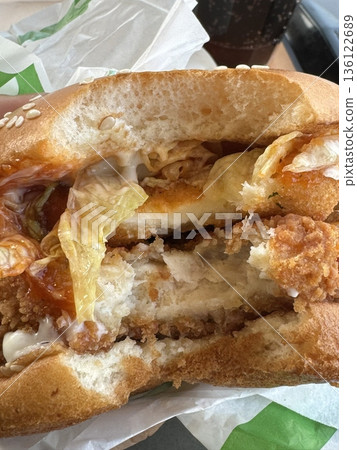 A mouthwatering burger with a juicy patty, fresh lettuce, tomato, and melted cheese, all nestled in a soft bun. Perfect for food photography, showcasing the indulgence of classic comfort food. 136122689