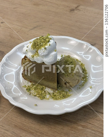 A delectable slice of cake with rich layers of cream and frosting, topped with fresh fruit or sprinkles. Perfect for dessert photography, showcasing indulgence and sweetness in food-related projects. 136122706