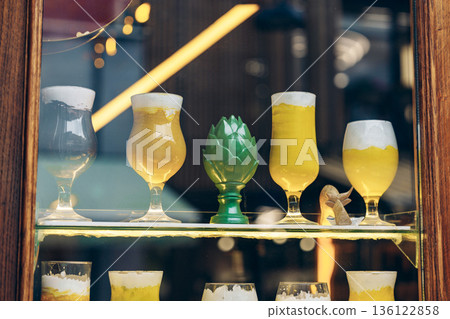 Different types of drinks displayed in a glass cabinet at a bar in the city 136122858