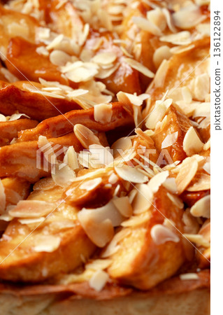 Fresh baked apple tart with sliced almonds for dessert in a cozy kitchen setting Fresh baked apple tart with sliced almonds for dessert in a cozy kitchen setting 136122894