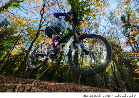 Thrilling Mountain Bike Jump Through Autumn Forest Trail Amid Sunlight Rider Adventure Outdoor Action Leaves Thrilling Mountain Bike Jump Through Autumn Forest Trail Amid Sunlight Rider Adventure Outdoor Action Leaves 136123139