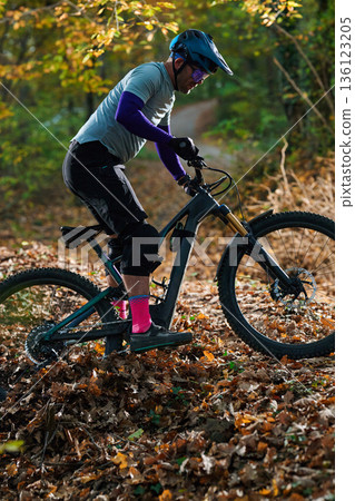 Autumn Mountain Biking On Leafy Trail With Rider In Helmet And Pink Socks Autumn Mountain Biking On Leafy Trail With Rider In Helmet And Pink Socks 136123205