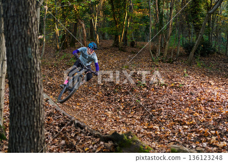 Dynamic Mountain Bike Rider Navigates Leafy Forest Trail With Speed And Focus Dynamic Mountain Bike Rider Navigates Leafy Forest Trail With Speed And Focus 136123248