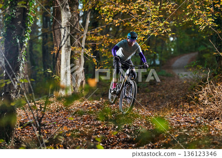 Mountain Bike Rider Navigates Autumn Forest Trail With Focused Energy and Outdoor Adventure Mountain Bike Rider Navigates Autumn Forest Trail With Focused Energy and Outdoor Adventure 136123346