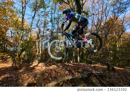 High-Flying Mountain Biker Jump Over Leafy Trail in Autumn Forest Adventure High-Flying Mountain Biker Jump Over Leafy Trail in Autumn Forest Adventure 136123392