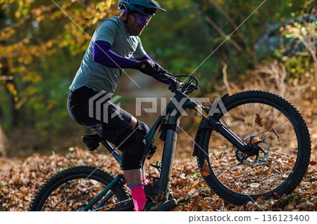 Mountain Biker Riding Through Autumn Forest Trail in Outdoor Adventure Scene With Gear Mountain Biker Riding Through Autumn Forest Trail in Outdoor Adventure Scene With Gear 136123400