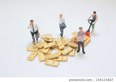 Miniature Workers Managing Stack Of Metallic Gold Bars 136123887