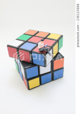 Miniature Reader Sitting Quietly Atop Colorful Rubik Cube Miniature Reader Sitting Quietly Atop Colorful Rubik Cube 136123888