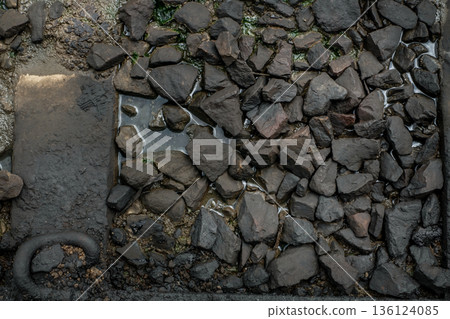 Ballast stone gravel soaked with engine oil in the railroad tracks. 136124085