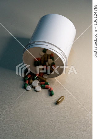 Medicine bottle spilling pills and capsules for healthcare 136124769