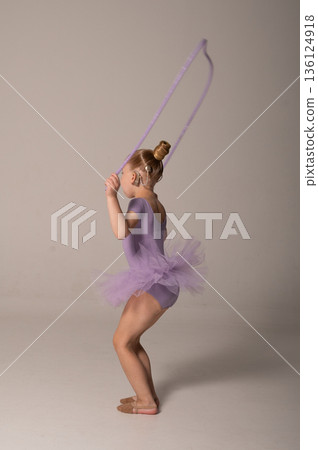 Young rhythmic gymnast child with cochlear implant using rope during practice. Hearing rehabilitation, cochlear implant treatment, inclusive sport activity, coordination training, and motor skill 136124918