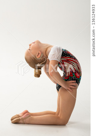 Rhythmic gymnastics child with cochlear implant performing backbend exercise. Hearing loss treatment, cochlear implantation recovery, body awareness, inclusive training, and pediatric rehabilitation 136124933