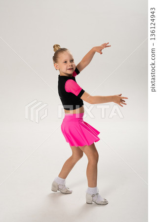 Child dancer with cochlear implant performing arm movement in studio. Hearing impairment treatment, auditory training, assistive medical technology, inclusive sport dance, and motor development 136124943