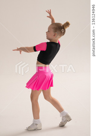 Child dancer with cochlear implant performing arm movement in studio. Hearing impairment treatment, auditory training, assistive medical technology, inclusive sport dance, and motor development 136124946