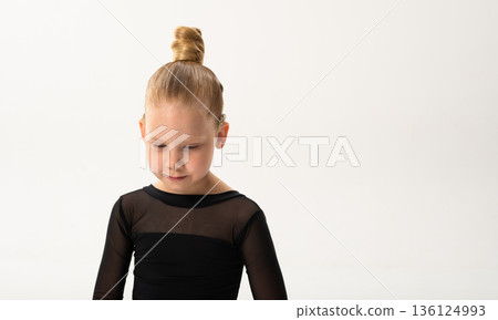Child with cochlear implant looking down during dance training session. Banner with copy space. Hearing impairment therapy, auditory rehabilitation, assistive technology, concentration development 136124993