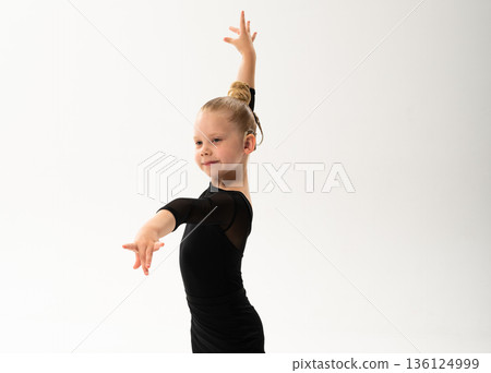 Child dancer with cochlear implant performing arm movement in studio. Hearing impairment treatment, auditory training, assistive medical technology, inclusive sport dance, and motor development 136124999