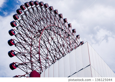 The modern exterior of the urban Ferris wheel stands out against the blue sky The modern exterior of the urban Ferris wheel stands out against the blue sky 136125044