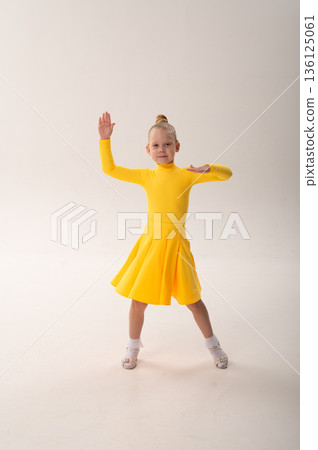 Young girl with cochlear implant performing dance pose in studio. Hearing impairment rehabilitation, auditory therapy, assistive hearing technology, inclusive childhood development, and confidence 136125061