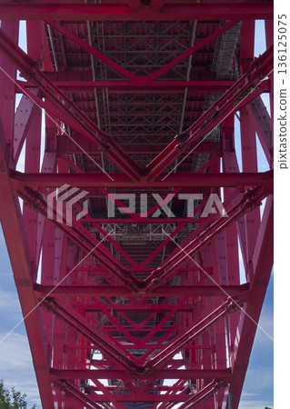 The vertically symmetrical structure of the red steel bridge seen from directly below 136125075