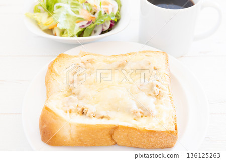 A delicious breakfast of thick-cut tuna and cheese toast, vegetable salad, and coffee A delicious breakfast of thick-cut tuna and cheese toast, vegetable salad, and coffee 136125263
