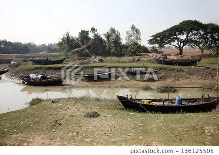 Boats of fishermen stranded in the mud at low tide on the coast of Bay of Bengal, India Boats of fishermen stranded in the mud at low tide on the coast of Bay of Bengal, India 136125505