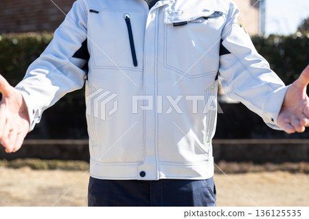 一名身穿工作服的男子伸出雙手,做出歡迎的姿態。 一名身穿工作服的男子伸出雙手,做出歡迎的姿態。 136125535