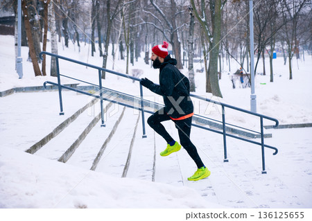 Man running upstairs during winter workout. Man running upstairs during winter workout. 136125655