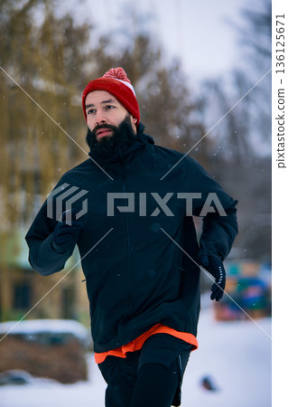 Bearded man jogging outdoors in winter park Bearded man jogging outdoors in winter park 136125671