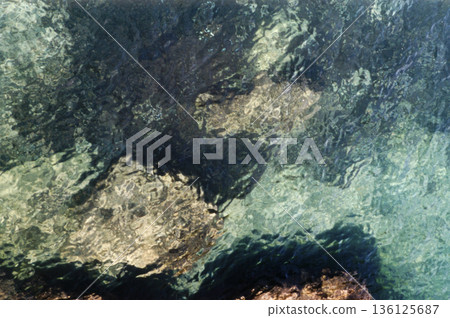 rocks on the seabed seen through transparent water 136125687