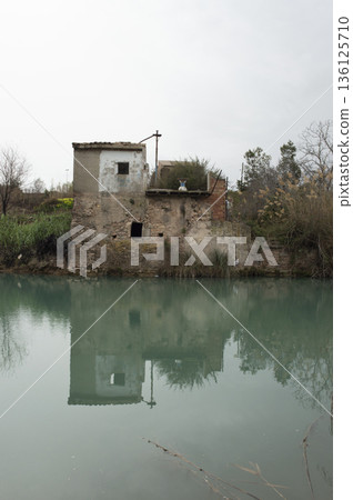 abandoned house in ruins by the river 136125710