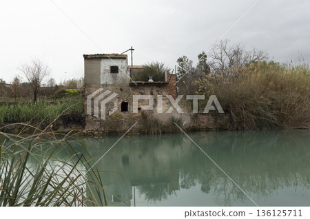 abandoned house in ruins by the river 136125711