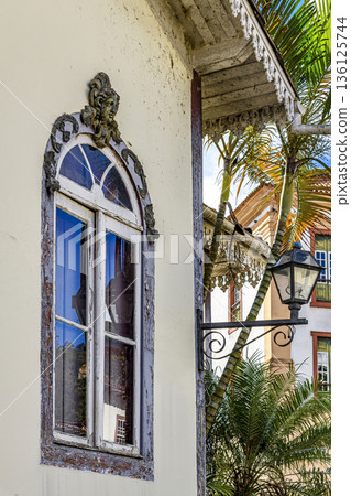 Old window decorated with a sculpture 136125744