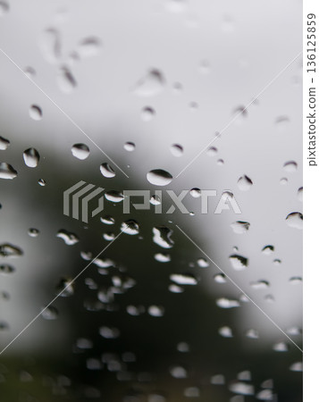Water drops moving down clear glass window Water drops moving down clear glass window 136125859