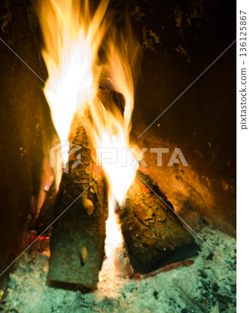 Fireplace with burning logs providing warmth and light Fireplace with burning logs providing warmth and light 136125867