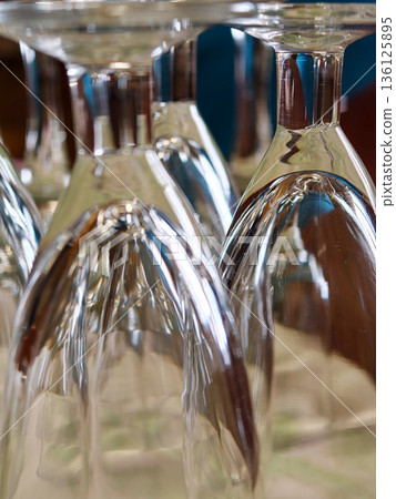 Inverted wine glasses reflecting light and colors 136125895