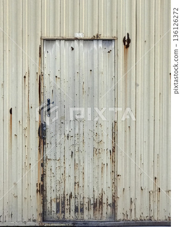 metal door of a deteriorated industrial warehouse metal door of a deteriorated industrial warehouse 136126272