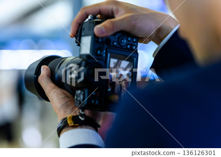 A man taking a photo with a camera. Photo courtesy of Kansai International Airport (KIX) 136126301