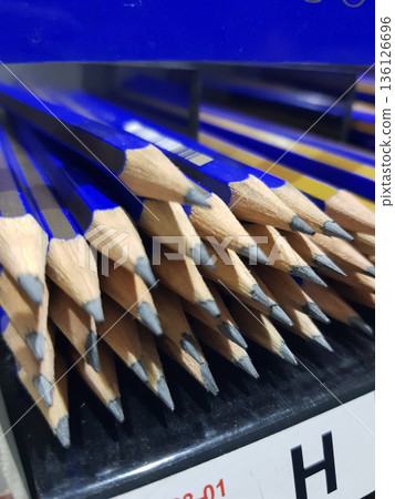 Many blue pencils are lined up with sharpened tips pointing outward. Many blue pencils are lined up with sharpened tips pointing outward. 136126696